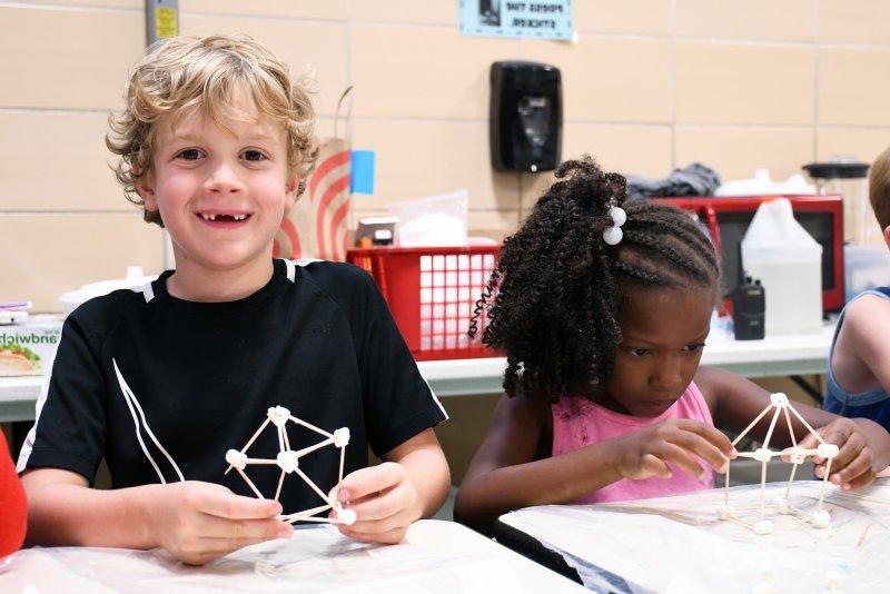 Two 万博体育官网 build structures out of marshmallows and toothpicks